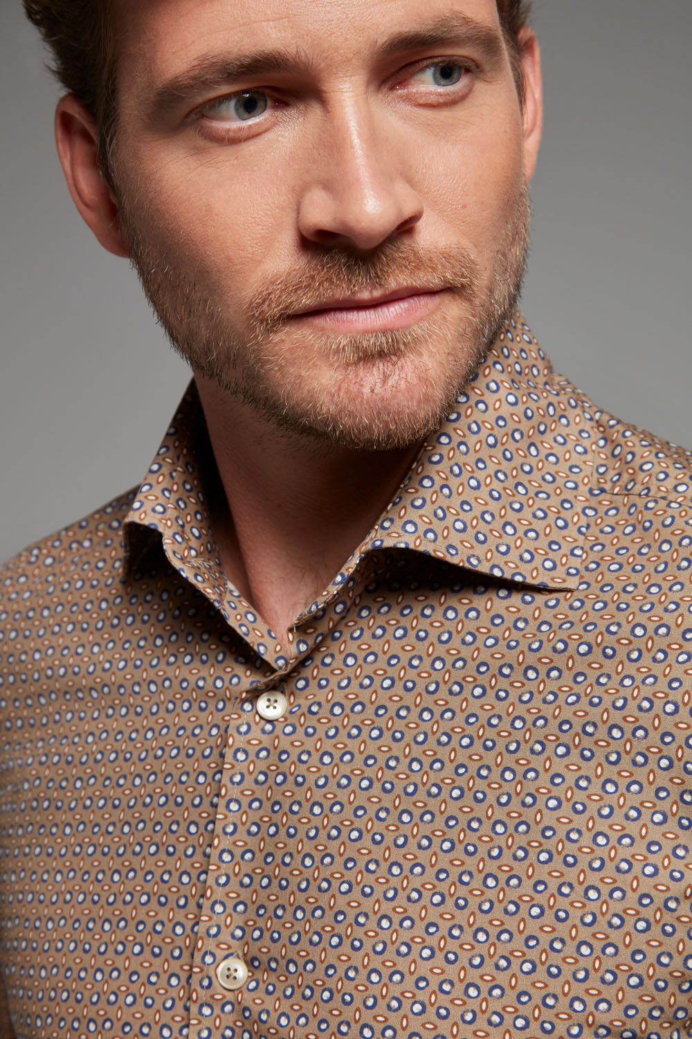 Dieses Einhorn Hemd mit geometrischem Print in Beige, Marineblau und Weiß kombiniert klassische Eleganz mit moderner Leichtigkeit.