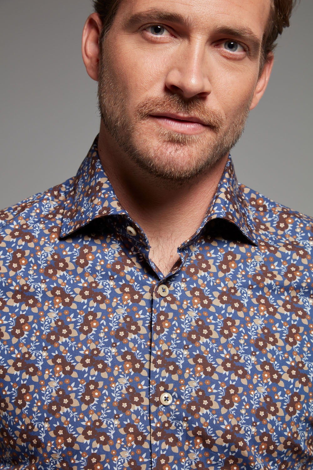 Dieses Einhorn Hemd mit floralem Print in Marineblau, Braun und Beige vereint Eleganz und Individualität in perfekter Balance.